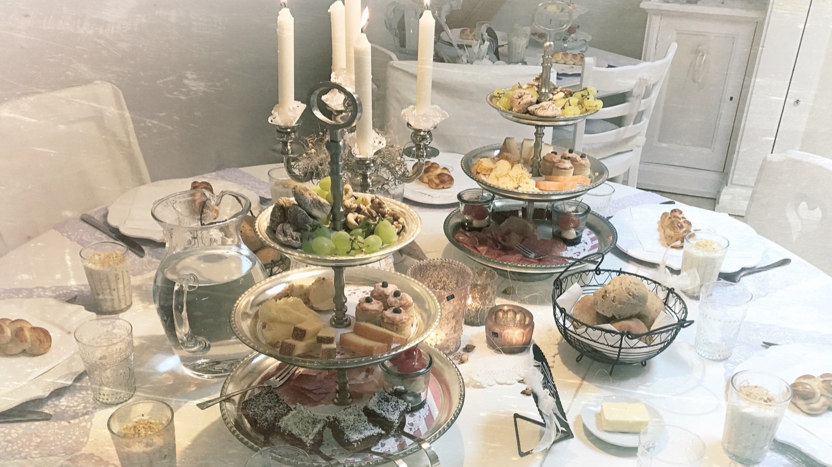Gedeckter Frühstückstisch im Bistro mit Etageren und Kerzenständern