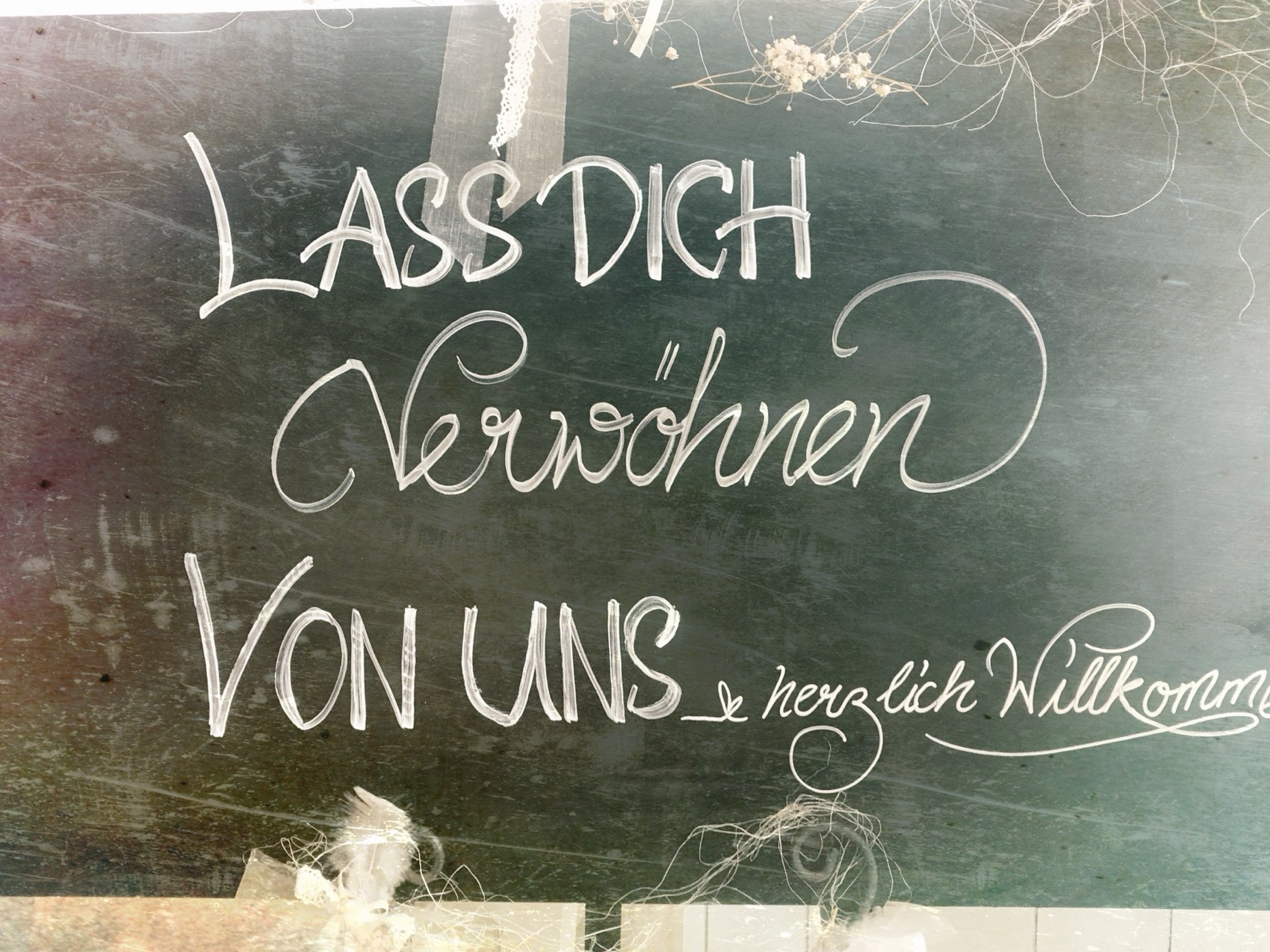 Tafel im Bistro: «Lass dich verwöhnen von uns, herzlich willkommen»